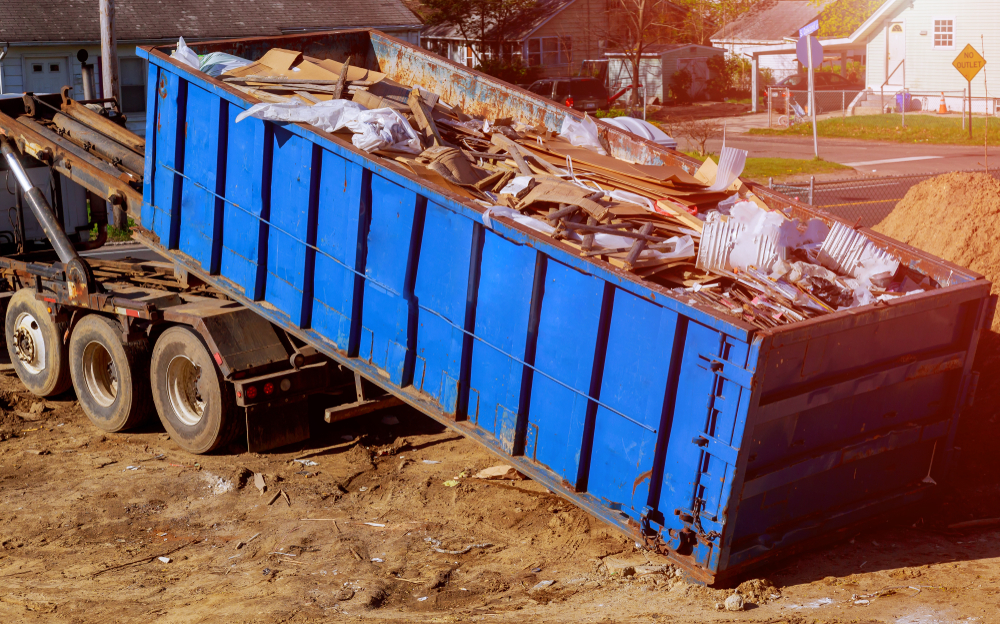 Blue,construction,debris,container,filled,with,rock,and,concrete,rubble.