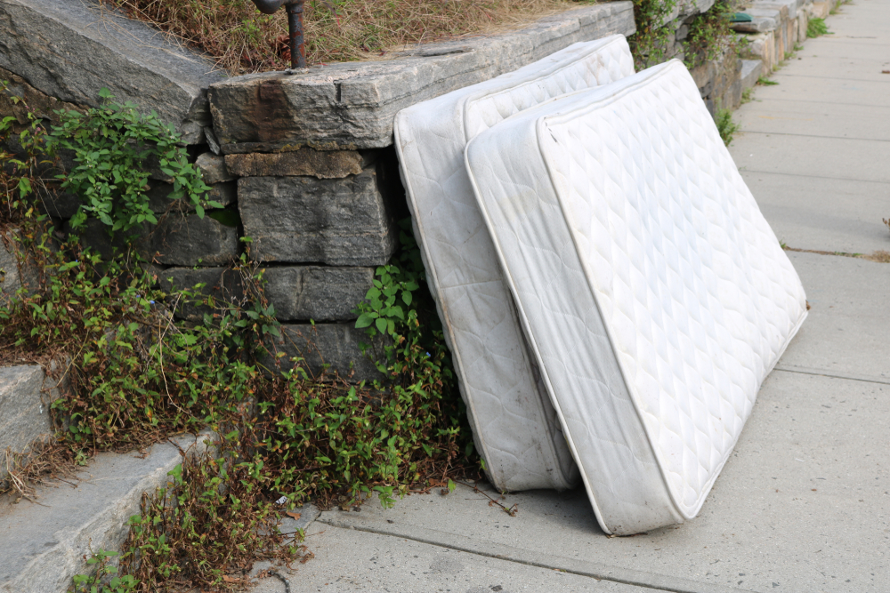 Old,discarded,mattress,left,outside,in,urban,alleyway